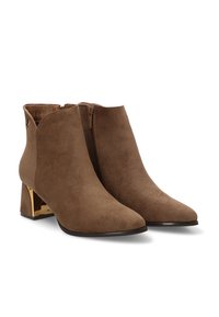 Botas de tobillo de ante marrón con puntera afilada, cierre de cremallera lateral y un tacón de bloque con acentos dorados. Textura suave y diseño minimalista.