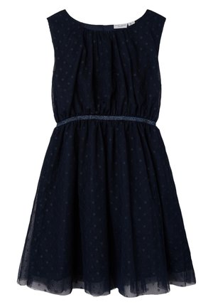 Robe bleu marine sans manches à pois subtils, taille froncée avec une fine ceinture tressée, et une jupe légèrement évasée.