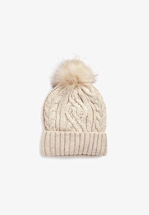 Bonnet d'hiver beige en tricot avec bord-côte et un grand pompon duveteux sur le dessus.
