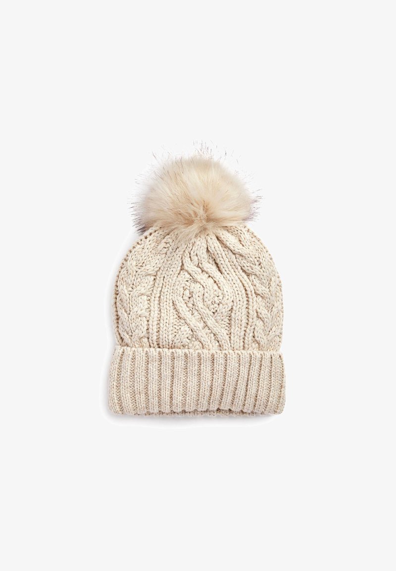 Bonnet d'hiver beige en tricot avec bord-côte et un grand pompon duveteux sur le dessus.