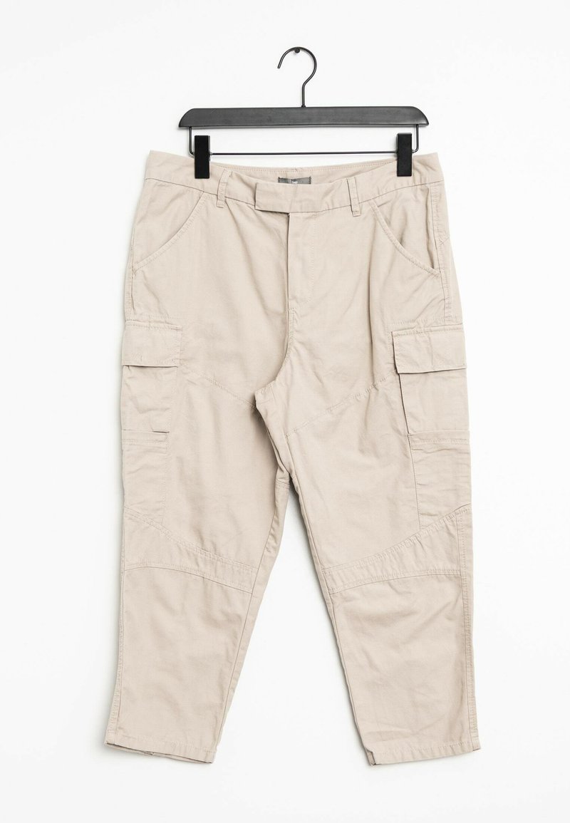 Pantalons cargo beiges en tissu léger, dotés de plusieurs poches latérales, d'une coupe détendue et de détails de couture visibles.