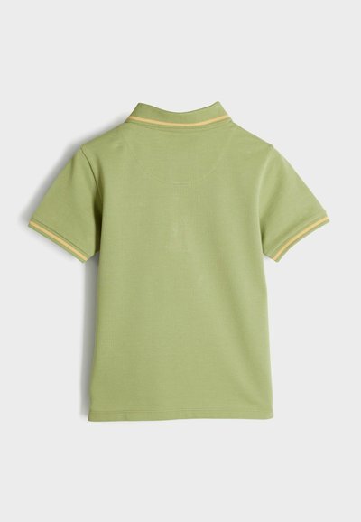 Polo in cotone verde chiaro con maniche corte, con colletto a righe gialle e texture liscia. La vista posteriore mostra un design semplice.