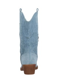 Bota de vaquero de ante azul claro con bordados intrincados, caña puntiaguda y suela marrón. Presenta un diseño decorativo de un águila en la parte trasera.