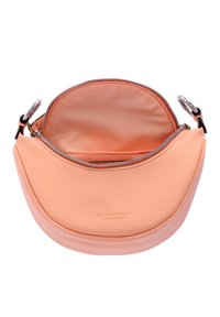 Bolso de cuero suave color durazno con forma curva, cremallera plateada y forro interior suave; presenta un estampado del logotipo en la parte frontal.