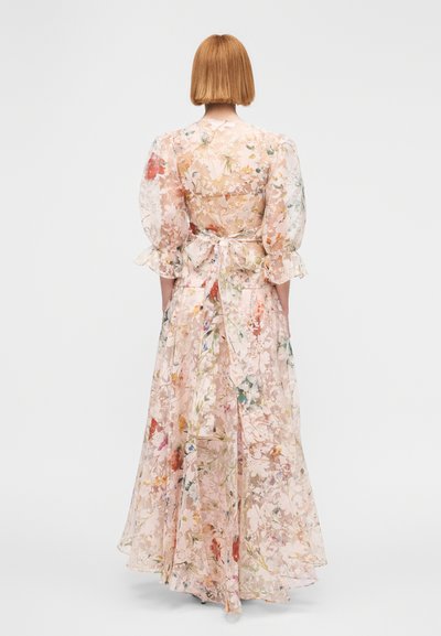 Robe longue en dentelle florale rose avec manches bouffantes et détail à nouer dans le dos. Caractérisée par une silhouette fluide à couches décorée de fleurs multicolores.
