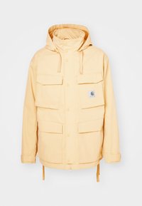 Giacca impermeabile gialla con cappuccio, quattro tasche frontali, chiusura con bottoni a pressione e orlo inferiore regolabile. Texture liscia, design casual.
