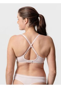 Helles rosa BH mit glatter Textur, verstellbaren Trägern, die sich am Rücken kreuzen, und einem Hakenverschluss. Kombiniert mit passender hellrosa Unterwäsche.