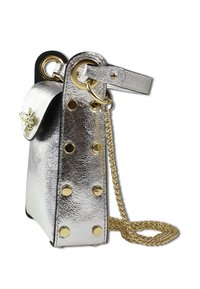 Sac à main en métal argenté avec un design structuré, ornée de clous dorés, d'un accent décoratif en forme d'abeille et d'une longue bandoulière en chaîne.