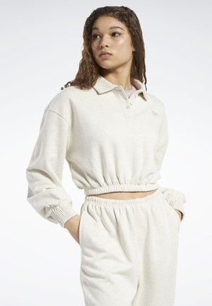 Cremefarbener Pullover mit Kragen, elastischem Bund und Bündchen. Kombiniert mit passenden, lässigen Hosen mit elastischem Taillenbund.