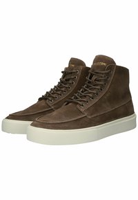 Bruine suède high-top sneakers met een witte rubberen zool, voorzien van metalen oogjes en veters, en een reliëflogo op de tong.