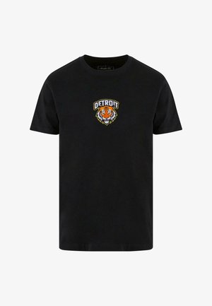 Must t-särk mustal taustal, millel on tiigri graafika ja "DETROIT" tekst üleval, valge ja oranži värviga. Klassikaline ümmargune kaelus ja lühikesed varrukad.