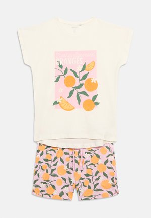 Haut crème à manches courtes avec un motif d'orange et de feuilles, accompagné d'un short rose couvert d'un motif assorti d'oranges et de feuilles vertes.