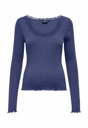 Navy blue ribbid pitkähihaisen paidan, jossa on nyörityksellä koristeltu kaula-aukko ja röyhelöhelma, valmistettu joustavasta kankaasta muotoilun saamiseksi.
