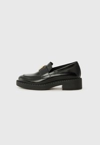 Black patent leather loafers with a chunky heel and contrasting black rubber sole. Features a decorative strap across the vamp.
