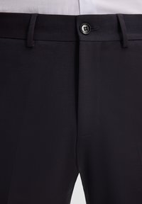 Donker gekleurde broeken van gladde stof met een slank ontwerp, voorzien van een voorste knoop, riemlussen en een discreet zakje.