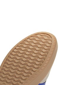 Suola in gomma con un motivo testurizzato, di colore beige. La parte superiore è blu e presenta dettagli in suede sui lati.
