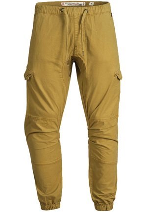 Pantaloni cargo jogger pentru bărbați, culoare muștar, cu talie elastică, șnur, buzunare laterale cu clapetă, cusături la genunchi și manșete elastice.