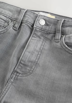 Blugi din denim gri cu textură netedă, prevăzuți cu închidere cu nasture metalic, buzunare frontale și cusături vizibile de-a lungul cusăturilor.