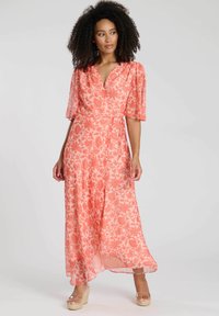 Korallenfarbenes, florales Maxikleid mit kurzen, puffärmeligen Ärmeln und Wickeldesign. Hergestellt aus leichtem Stoff mit fließender Textur. Mit taillierendem Bindegürtel.