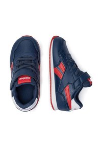 Zapatillas para toddlers en azul marino y rojo con correas de Velcro, paneles de malla y acentos en blanco, mostrando vistas superior y lateral sobre un fondo blanco.