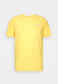 Žluté atletické tričko s krátkým rukávem vyrobené z lehkého materiálu s raglánovými rukávy. Vybaveno malým stříbrným logem na hrudi.