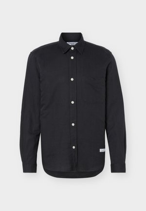 Camisa negra de manga larga con botones, un solo bolsillo en el pecho, cuello puntiagudo y una pequeña etiqueta blanca cerca del dobladillo inferior sobre un fondo blanco.