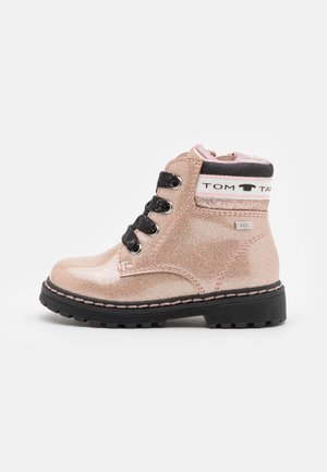 Bottine rose pailletée pour enfants avec lacets noirs, semelle noire épaisse, col blanc et noir avec logo, et doublure rose douce.