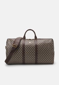 Brown patterned duffel bag with leather accents, featuring a woven texture, dual handles, and an adjustable shoulder strap. Gold hardware detail.