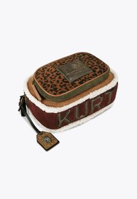 Brązowa torba z nadrukiem w panterkę z beżowym futrem syntetycznym w środku. Posiada metalową naszywkę z logo oraz bordową podstawę z wytłoczonym napisem "KURT".