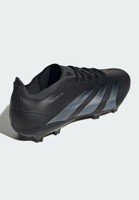 Scarpa da calcio sintetica nera con superficie texturizzata, design elegante, accenti argentati prominenti e sei tacchetti conici sulla suola.