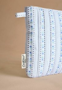 Modrý textilný vrecko s vertikálnymi pruhmi, kvetinovými vzormi, sivými bodkami a horným zipsom. Má textilnú visačku s nápisom "Cath Kidston."