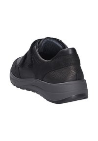 Scarpa nera in pelle con tomaia testurizzata, cinturini in Velcro e una spessa suola in gomma grigia. Tacco arrotondato e branding minimo sul lato.