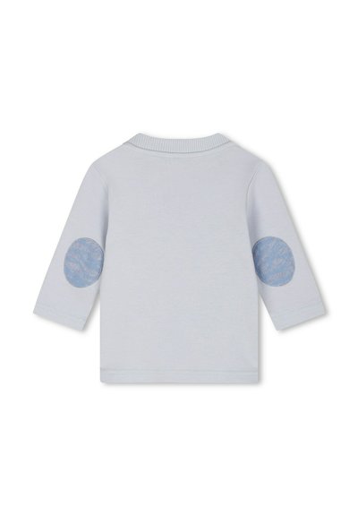 Chemise à manches longues bleu clair avec un col à côtes et des épaulettes texturées bleu. Tissu lisse avec un design simple et un ourlet droit.