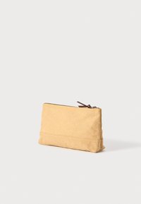 Pochette en tissu jaune avec une surface texturée, de forme rectangulaire, fermeture éclair sur le dessus et tirage en cuir marron.