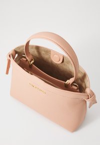 Persikofärgad läderhandväska med en texturerad yta, handtag upptill, innerfack med dragkedja och detaljer i guld. Mjukfodrad insida. Valentina-logotypen är tydligt synlig.