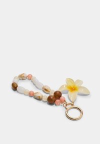 Porte-clés floral avec une fleur en résine jaune, des perles multicolores comprenant du marron, du rose et du blanc translucide, avec un anneau en métal doré.