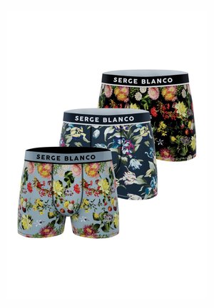 Trois paires de boxers avec des motifs floraux colorés et des ceintures de marque "SERGE BLANCO" en noir, bleu marine et bleu clair.