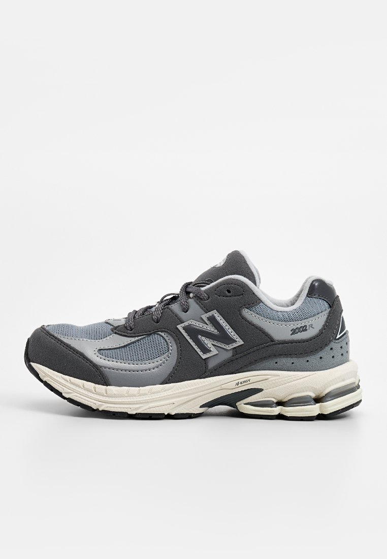 Zapatilla de correr gris con parte superior de malla y superposiciones sintéticas. Presenta una entresuela con amortiguación, suela texturizada y acentos reflectantes. Modelo 2002R.