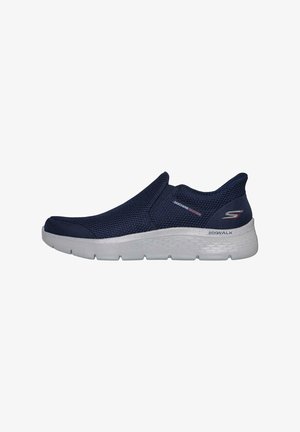 Scarpa slip-on in rete blu navy con suola bianca, caratterizzata da una finitura testurizzata, profilo basso e logo Skechers sul lato; progettata per comfort e praticità.