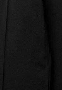 Tissu noir à la texture lisse et légèrement brillante. Le matériau semble épais et durable, avec de subtiles détails de couture.