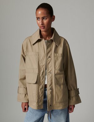 Kurtka robocza w kolorze khaki z zapięciem na guziki z przodu, dużymi przednimi kieszeniami i regulowanymi mankietami. Wykonana z trwałej, gładkiej tkaniny.