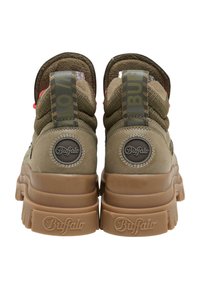 Ζευγάρι chunky sneakers Buffalo σε μπεζ και καφέ χρώμα, εμφανιζόμενα από πίσω, με παχιά σόλα και μπρελόκ με το λογότυπο.