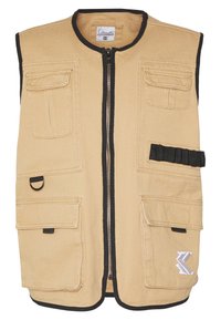 Khakifärgad väst med dragkedja framtill, svart kant, flera fickor fram och en dekorativ logotyp. Tillverkad av slitstarkt tyg med en mjuk struktur.