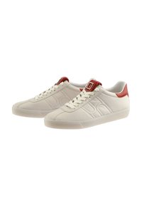 Weiße Leder-Sneaker mit strukturiertem Finish, roten Akzenten, Schnürung vorne und einem rechteckigen Schnallen-Detail nahe dem Kragen.