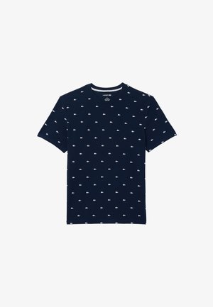 Navyblauwe t-shirt van katoen met een ronde hals, korte mouwen en een wit Lacoste-logo patroon dat gelijkmatig over de stof is verdeeld.