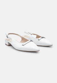 Valged nahast slingback kingad, millel on terav varvas, väike plokk-konts ja hõbedane detail vampi kohal. Sile tekstuur, minimaalne disain.