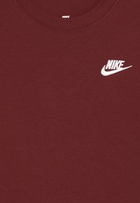 Burgundia puuvillane T-särk, millel on klassikaline ümmargune kaelus ja valge tikandiga Nike logo rinnal. Pehme ja siledapinnaline tekstuur.