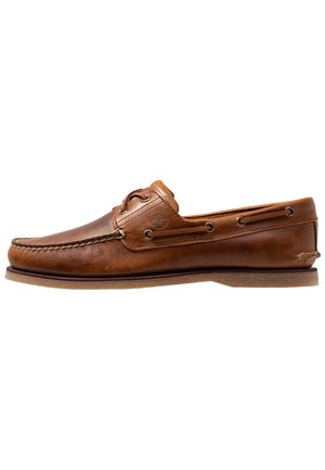 Chaussure bateau en cuir marron avec couture moc toe, détails lacets, logo Timberland et semelle en caoutchouc, vue de côté extérieur.