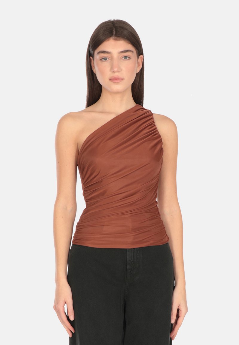 Top marrone a spalla unica realizzato in tessuto elasticizzato drappeggiato; presenta una texture arricciata e una silhouette aderente, abbinato a pantaloni scuri.