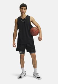 Čierna sieťovaná bezrukávová basketbalová dres, kombinovaný s čiernymi šortkami s svetlo šedými akcentmi. Subjekt drží basketbal a má na sebe šedé tenisky.